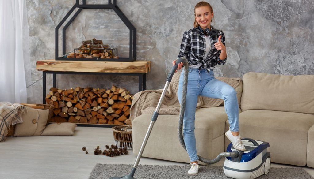 Slim woman cleaning with vacuum cleaner carpet