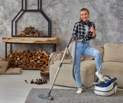 Slim woman cleaning with vacuum cleaner carpet