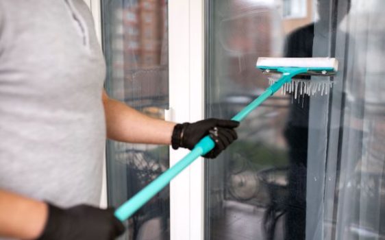 Ground-level window cleaner working on storefront windows in Waterford